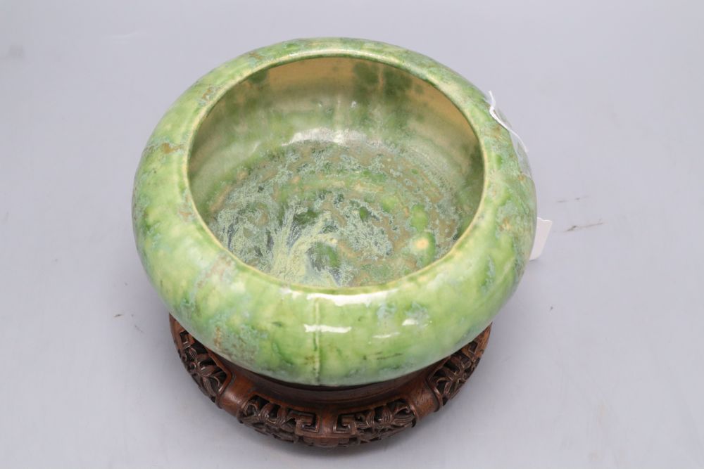 A Chinese green and straw-coloured crackle glaze brushwasher, Qing dynasty hongmu stand, height 13cm overall